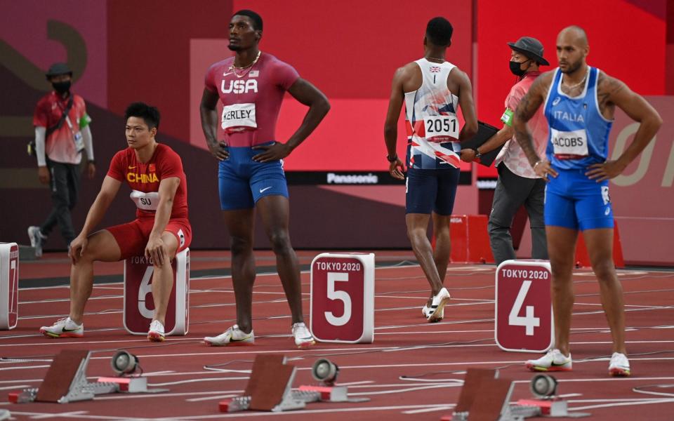 Zharnel Hughes has to leave the track after being disqualified for a false start  - AFP