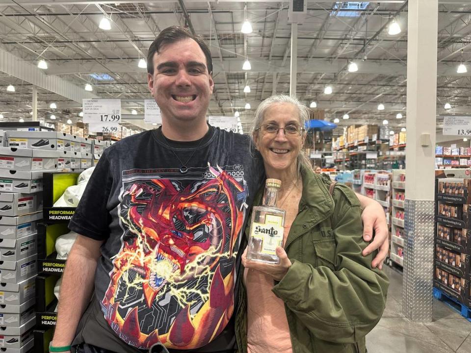 Anthony Naud and his mother pose while waiting in line to receive a signature from celebrity chef Guy Fieri on Fieri’s tequila bottle at Costco in San Luis Obispo on March 6, 2024.