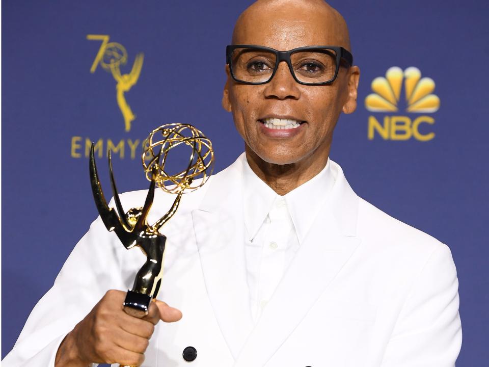 RuPaul holding up one of his emmys