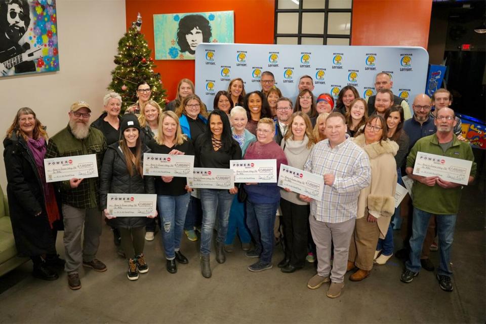78 members of The Heroes to Zeroooos Lottery Club in Traverse City pose after they split a $1 million Powerball prize. The members each received approximately $12,800.
