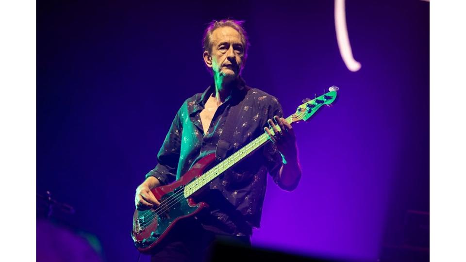 Mat Osman playing bass guitar on stage