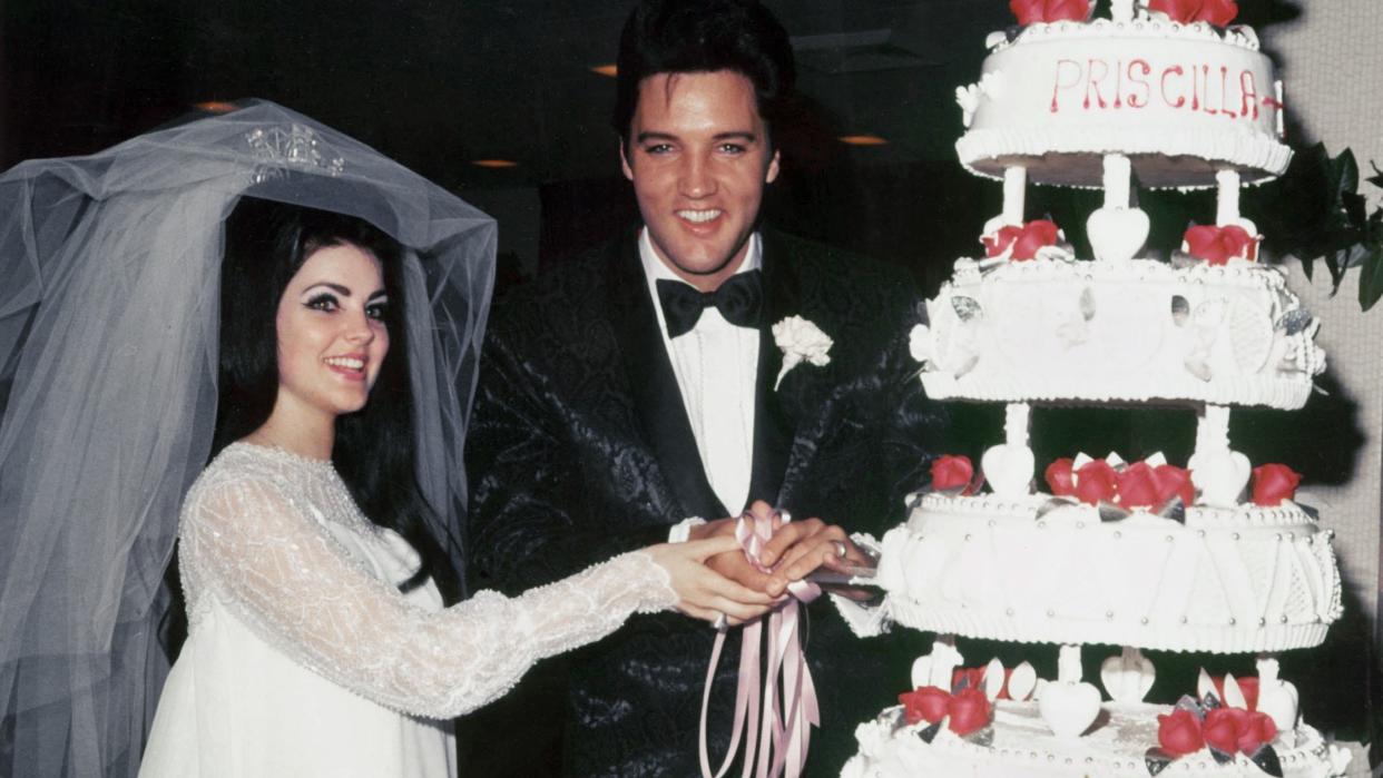 priscilla and elvis presley cutting their wedding cake