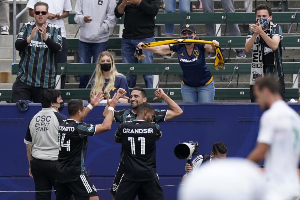 Galaxy midfielder Sebastian Lletget celebrates with teammates Samuel Grandsir and forward Javier "Chicharito" Hernández.