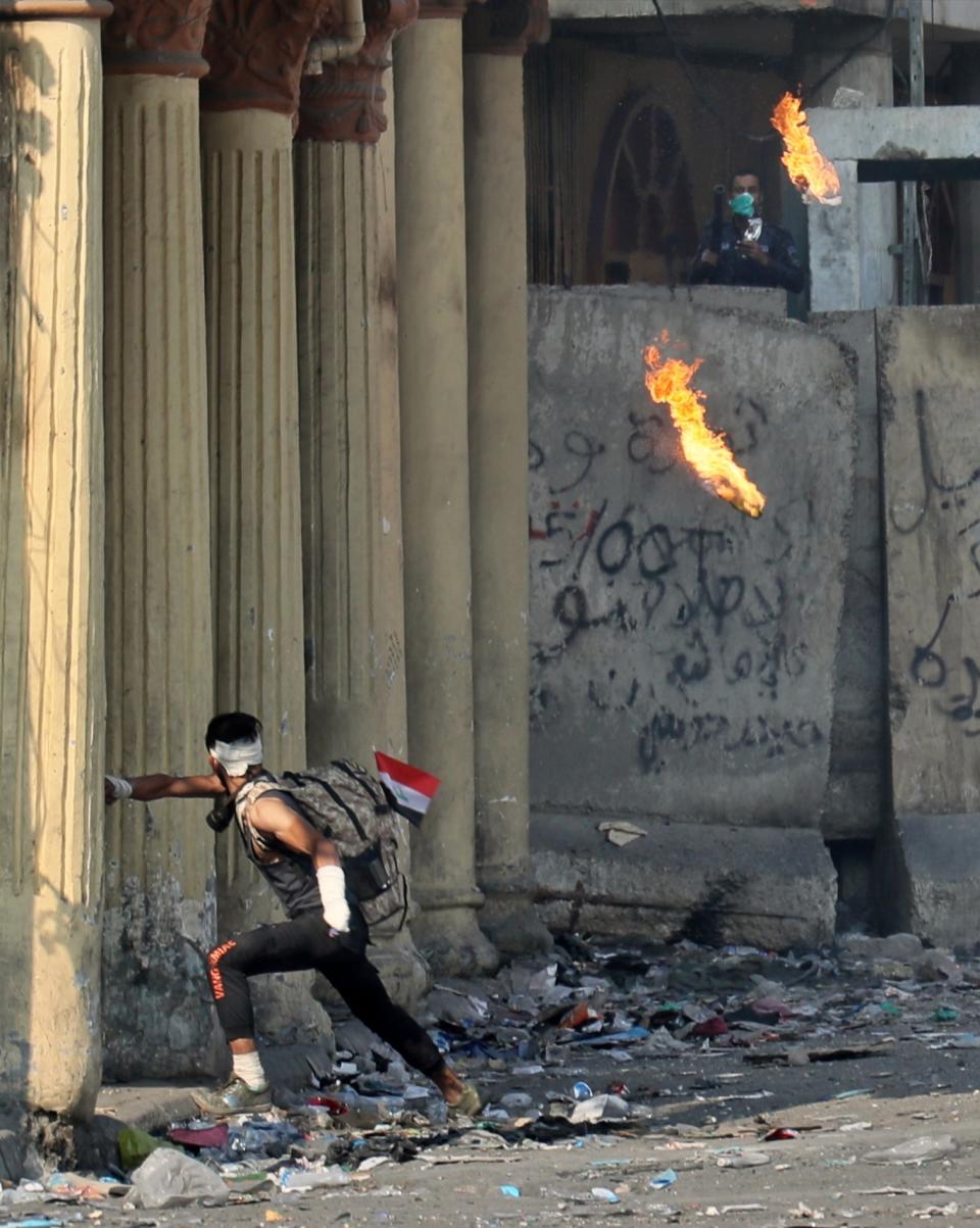 An anti-government protester throws a Molotov cocktail toward riot police during clashes on Rasheed Street, Baghdad, Iraq, Tuesday, Nov. 26, 2019. (AP Photo/Khalid Mohammed)