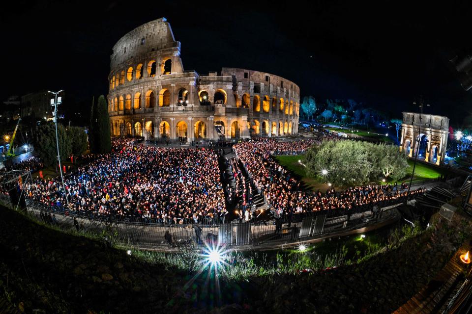 A general view shows people gather by the Colosseum monument in Rome during the Way of the Cross (Via Crucis) prayer service in Rome on April 7, 2023 as part of celebrations of the Holy Week.