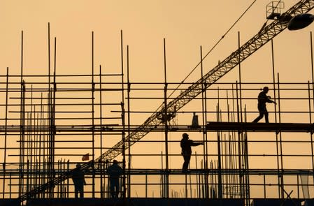 FILE PHOTO: Workers are seen on scaffolding at a construction site in Nantong