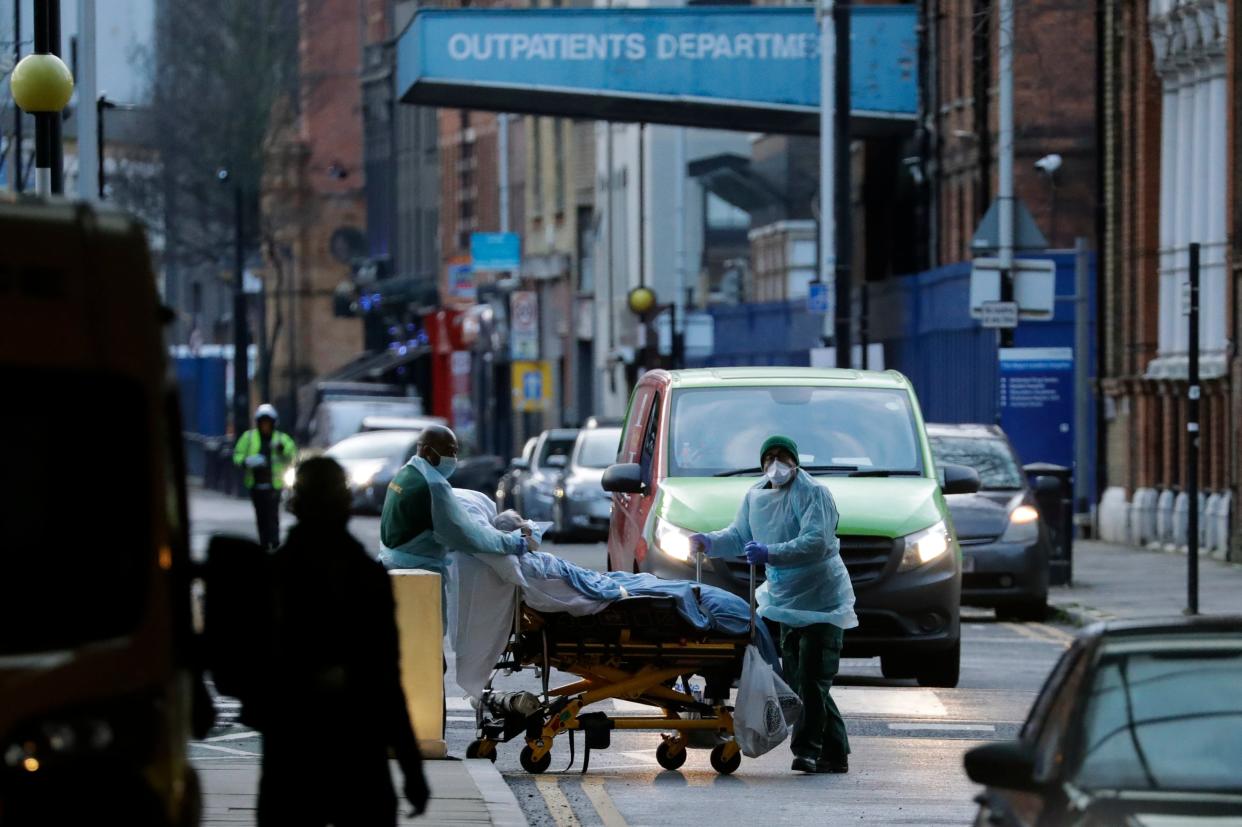 <p>A patient is pushed on a trolley outside the Royal London Hospital in east London</p> (AP)