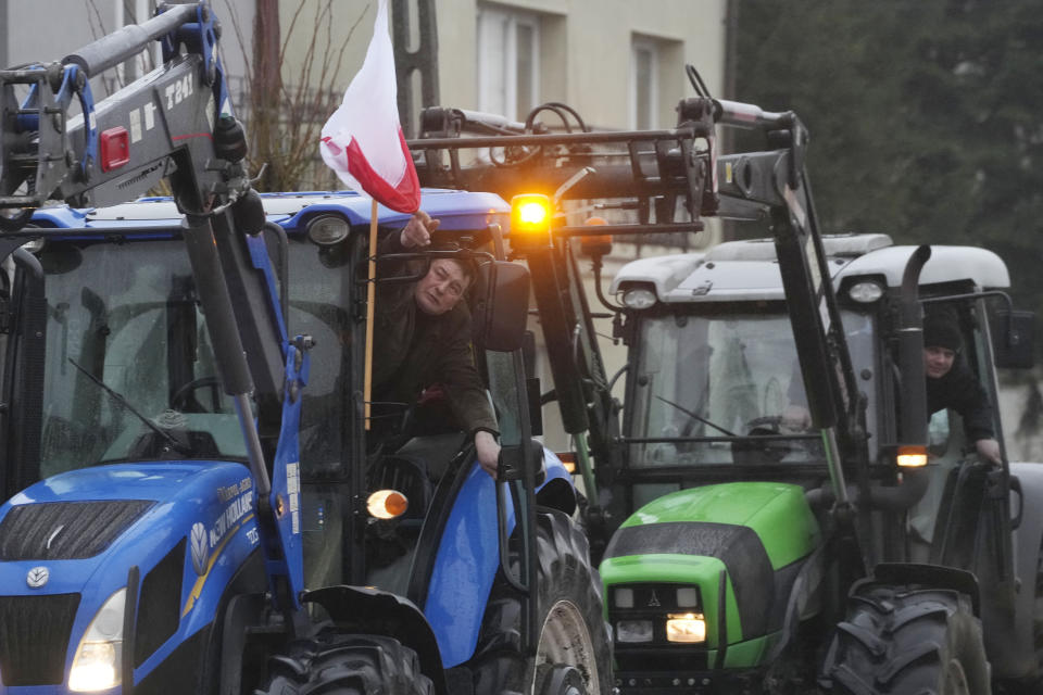 Protesting farmers in Poland are slow-driving their tractors on a road in Deblin, Poland, Wednesday, Jan. 24, 2024 to disturb traffic and draw attention to their disagreement to European Union regulations. Such protests were held across Poland. (AP Photo/Czarek Sokolowski)