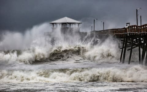 Waves slam the Oceana Pier & Pier House Restaurant in Atlantic Beach, North Carolina  - Credit: Travis Long