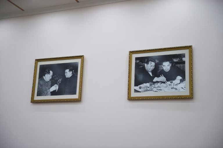 Photos of late North Korean leader Kim Il-Sung meeting with late Chinese leaders Mao Zedong (L) and Zhou Enlai hang on a wall at the North Korean embassy in Beijing on July 28, 2015