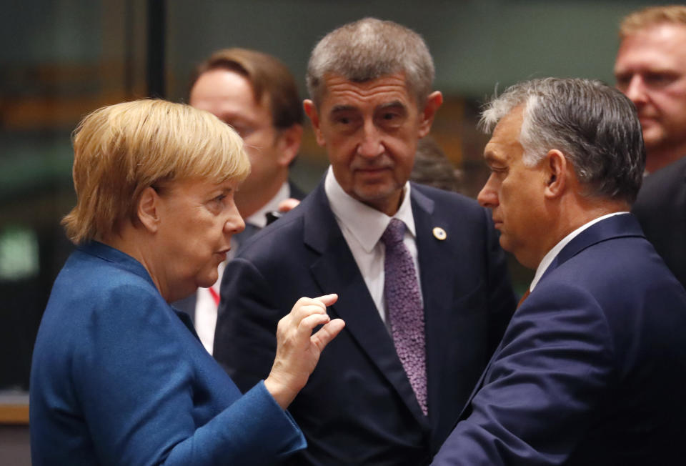 German Chancellor Angela Merkel, left, speaks with Hungarian Prime Minister Viktor Orban, second right, during a round table meeting at EU summit in Brussels, Friday, Oct. 18, 2019. After agreeing on terms for a new Brexit deal, European Union leaders are meeting again to discuss other thorny issues including the bloc's budget and climate change. (AP Photo/Frank Augstein)