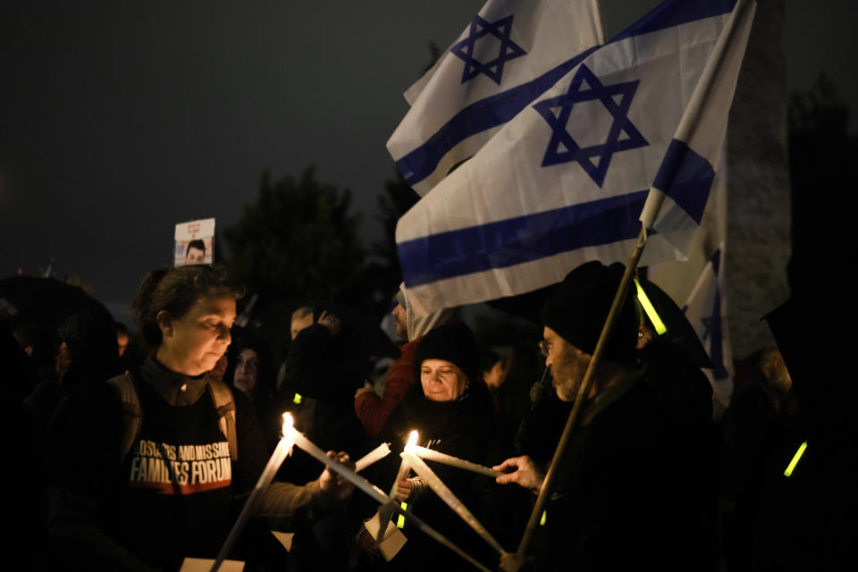 Relatives and friends of hostages held in the Gaza Strip by the Hamas militant group hold candles and call for their release during the Jewish holiday of Hanukkah, in Jerusalem, Tuesday, Dec. 12, 2023. (AP Photo/Leo Correa)