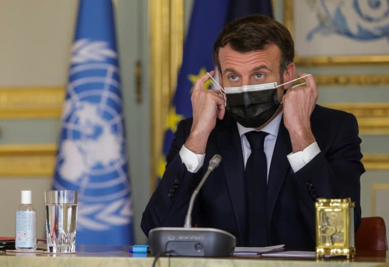 Le président français Emmanuel Macron ajuste son masque lors d'une visioconférence du Conseil de sécurité de l'ONU le 23 février 2021 - Christophe PETIT TESSON © 2019 AFP