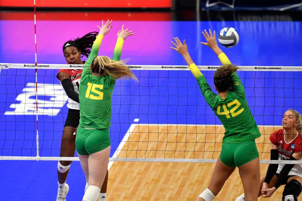 Louisville's Hannah Sherman (11) hits over Oregon's Mimi Colyer (15) and Karson Bacon (42) during their NCAA Regional Final game, Saturday, Dec. 10 2022 in Louisville Ky.