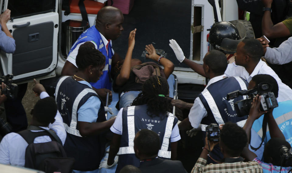Kenya medics put an injured person in ambulance after a blast in Nairobi, Kenya, Tuesday, Jan. 15, 2019. Extremists launched a deadly attack on a luxury hotel in Kenya's capital Tuesday, sending people fleeing in panic as explosions and heavy gunfire reverberated through the complex. A police officer said he saw bodies, "but there was no time to count the dead." (AP Photo/Brian Inganga)