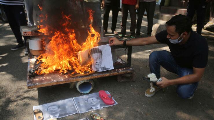 Ein Inder verbrennt das Bild des chinesischen Präsidenten Xi Jinping aus Protest gegen die chinesische Regierung. Foto: dpa