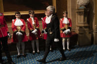 Black Rod, Sarah Clarke the first woman to serve in the role of Black Rod, walks past page boys in the Norman Porch at the Palace of Westminster and the Houses of Parliament for the State Opening of Parliament ceremony in London, Monday, Oct. 14, 2019. (AP Photo/Matt Dunham, Pool)