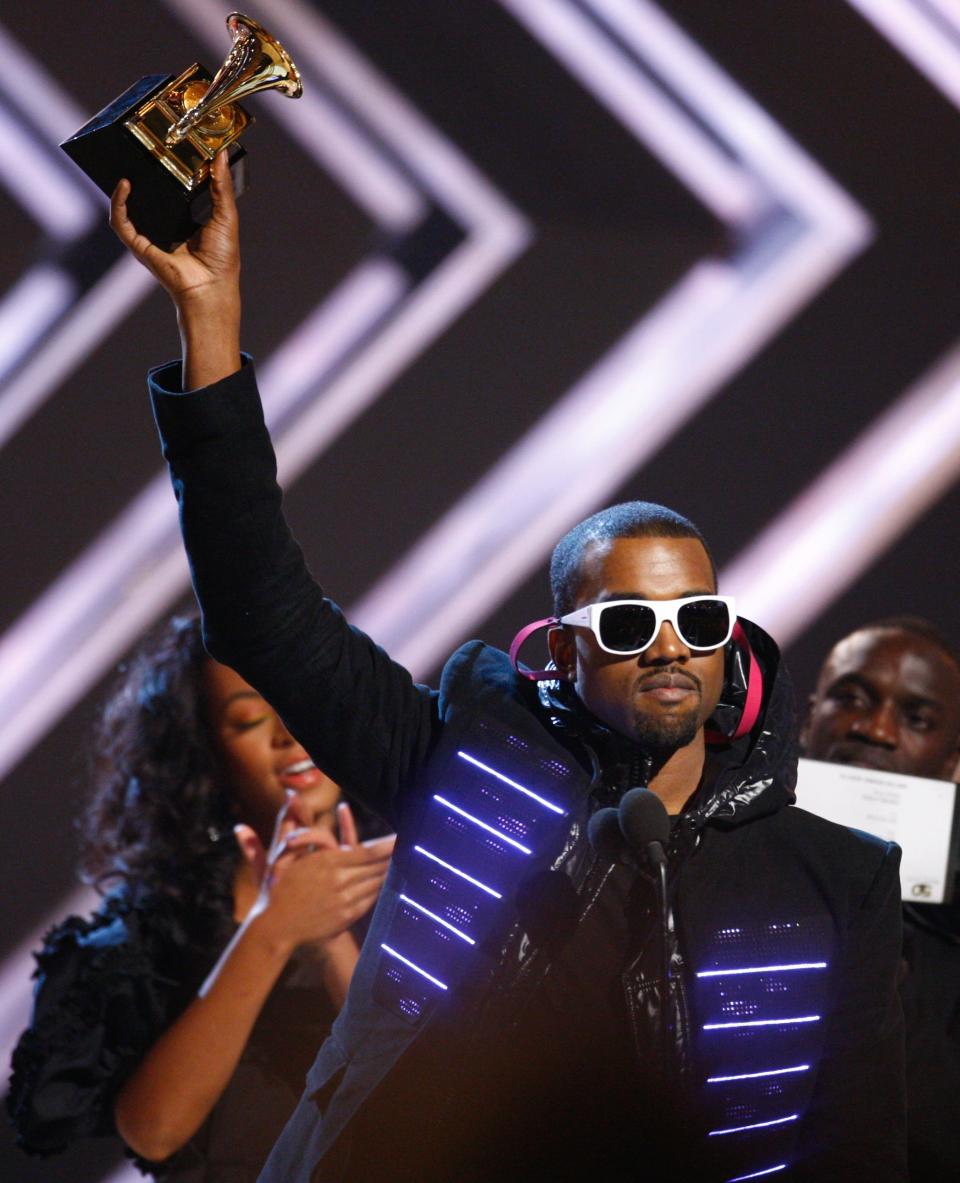 Rapper Kanye West hoists his Grammy award onstage in 2008. West has been awarded 22 Grammys throughout his career as a producer and rapper. 