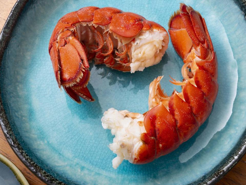 plate of lobster with lemon zest on wood