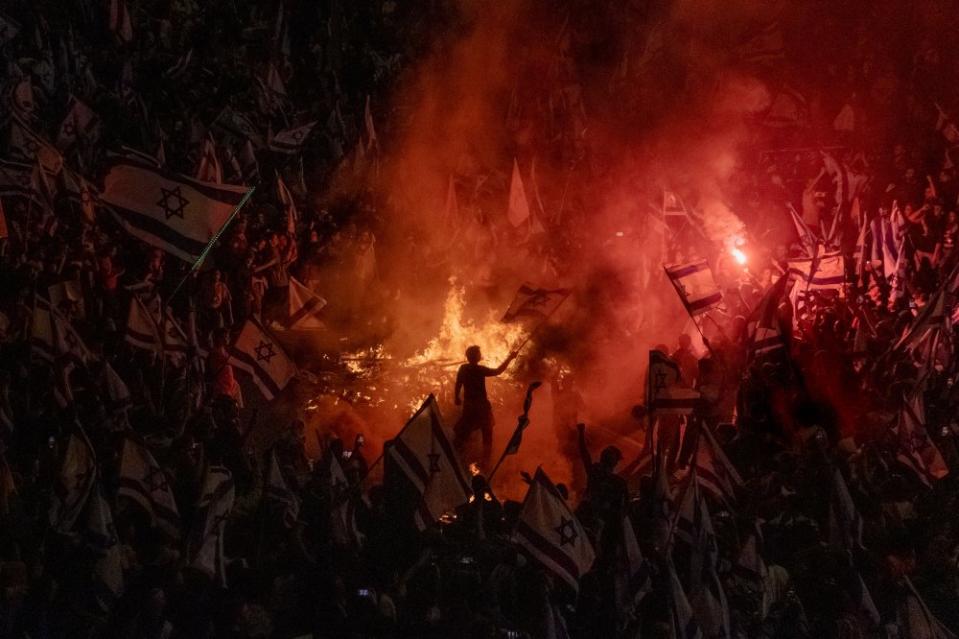 Israelis opposed to Prime Minister Benjamin Netanyahu's judicial overhaul plan set up bonfires, firecrackers and block a busy highway during a protest in Tel Aviv, moments after the Israeli leader fired his defense minister, on March 26.<span class="copyright">Amit Elkayam</span>