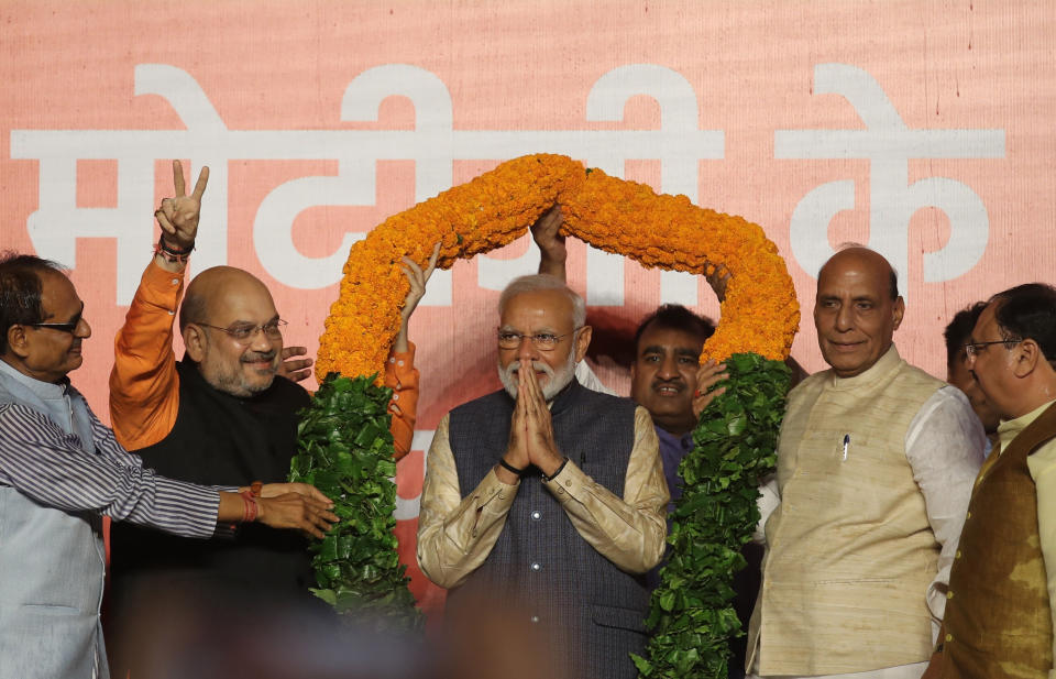 Bharatiya Janata Party (BJP) President Amit Shah, second left, and Home Minister Rajnath Singh, second right, present a giant floral garland to Indian Prime Minister Narendra Modi at the party headquarters in New Delhi, India, Thursday, May 23, 2019. Indian Prime Minister Narendra Modi's party claimed it had won reelection with a commanding lead in Thursday's vote count, while the stock market soared in anticipation of another five-year term for the pro-business Hindu nationalist leader. (AP Photo/Manish Swarup)