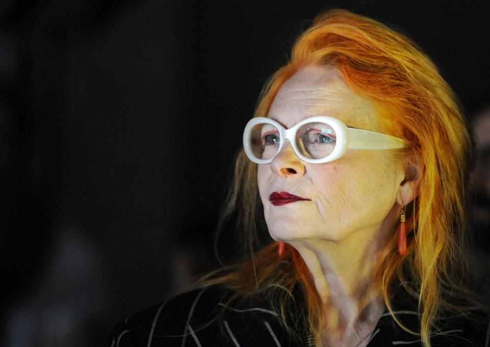 An older woman with copper hair and large white glasses