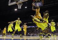Tennessee's Jordan McRae shoots over Michigan's Derrick Walton Jr. and Caris LeVert (23) during the second half of an NCAA Midwest Regional semifinal college basketball tournament game Friday, March 28, 2014, in Indianapolis. (AP Photo/David J. Phillip)