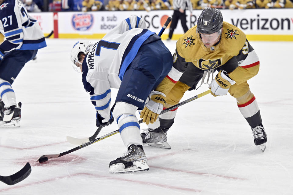 Vegas Golden Knights center Jack Eichel (9) reaches for the puck against Winnipeg Jets center Vladislav Namestnikov (7) during the second period of Game 5 of an NHL hockey Stanley Cup first-round playoff series Thursday, April 27, 2023, in Las Vegas. (AP Photo/David Becker)