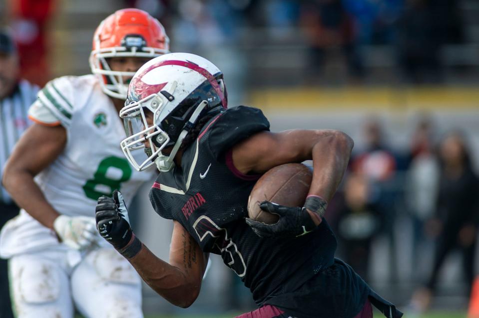 Peoria High's Eddie Clark runs the ball during the playoff game in Peoria Stadium on Saturday, Oct. 30, 2021. The Mustangs beat the Lions 50-42.