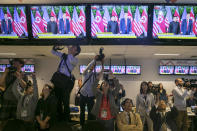 <p>Members of the media watch as television screens display a news broadcast of President Donald Trump and North Korean leader Kim Jong Un meeting at a summit, inside the media center for the DPRK-USA Singapore Summit in Singapore, on Tuesday, June 12, 2018. (Photo: Brent Lewin/Bloomberg via Getty Images) </p>