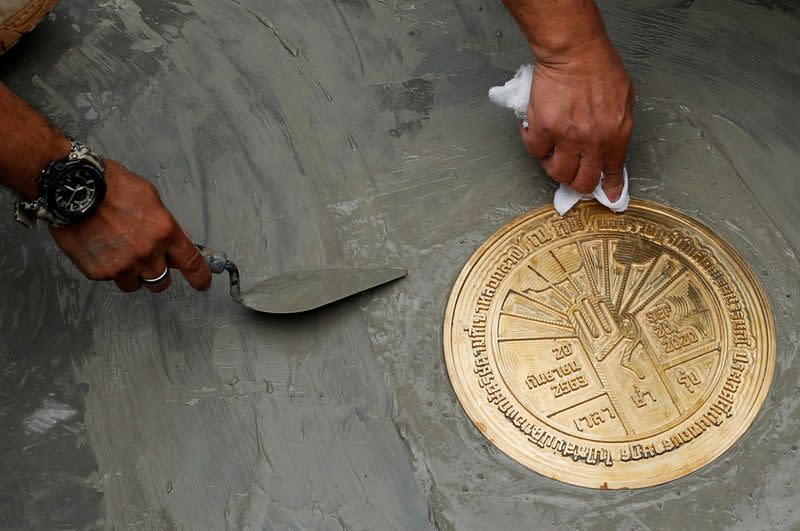 Student leaders install a plaque declaring "This country belongs to the people" during a mass rally to call for the ouster of Prime Minister Prayuth Chan-ocha and reforms in the monarchy, near the Grand Palace in Bangkok