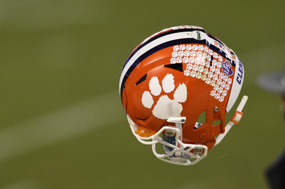 Dec 19, 2020; Charlotte, NC, USA; Clemson Tigers quarterback Trevor Lawrence (16) tosses his helmet to a manager after the ACC Football Championship at Bank of America Stadium. Mandatory Credit: Bob Donnan-USA TODAY Sports