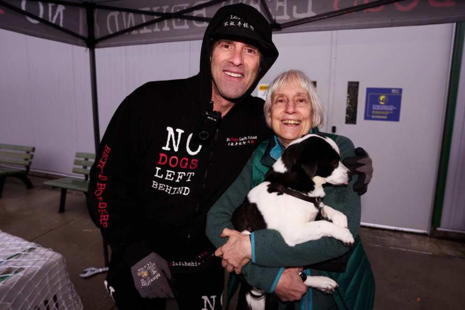 Beri poses with Joan Downing of Boston, Massachusetts, and her dog, Theo. The group rescued Theo three years ago in similar fashion. James Keivom