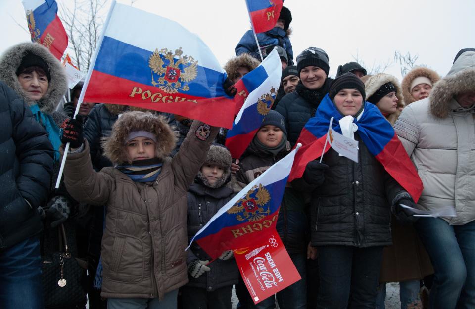 In this photo provided by Olympictorch2014.com, citizens welcome the Olympic torch relay in Rostov-on-Don, a city about 1,000 kilometers (600 miles) south of Moscow, Russia, Wednesday, Jan. 22, 2014. The 65,000-kilometer (40,389 mile) Sochi torch relay, which started on Oct. 7, is the longest in Olympic history. The torch has traveled to the North Pole on a Russian nuclear-powered icebreaker and has even been flown into space. (AP Photo/Olympictorch2014.com)