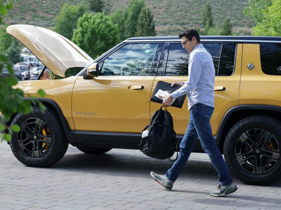 Rivian CEO RJ Scaringe walks next to Rivian truck at Sun Valley conference