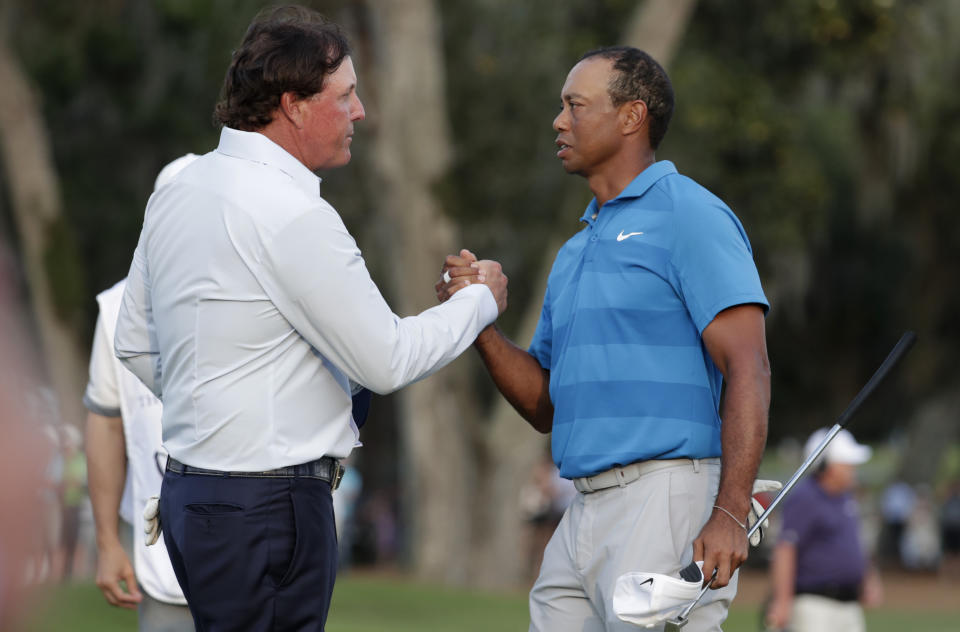 Phil Mickelson, left, and Tiger Woods shake hands after the first round of the Players Championship golf tournament Thursday, May 10, 2018, in Ponte Vedra Beach, Fla. (AP)