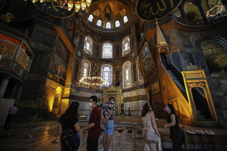 People visit the Byzantine-era Hagia Sophia, one of Istanbul's main tourist attractions in the historic Sultanahmet district of Istanbul on Thursday, June 25, 2020. The 6th-century building is now at the center of a heated debate between conservative groups who want it to be reconverted into a mosque and those who believe the World Heritage site should remain a museum. (AP Photo/Emrah Gurel)