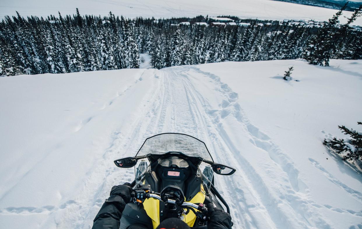 Going down a large hill on the back of a snowmobile in the Thaidene N&euml;n&eacute; Indigenous Protected Area. (Photo: Angela Gzowski for HuffPost)