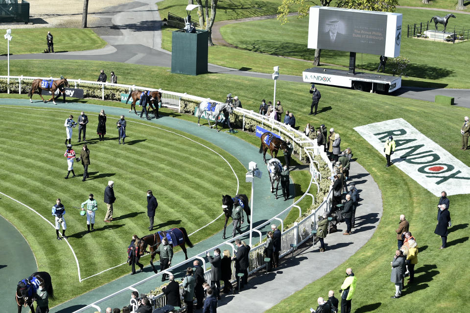 A video screen shows a picture of the late Prince Philip, Duke of Edinburgh, ahead of the races on the second day of the Grand National Horse Racing meeting at Aintree racecourse, near Liverpool, England, Friday April 9, 2021. Buckingham Palace says Prince Philip, the irascible and tough-minded husband of Queen Elizabeth II, has died. He was 99. (Peter Powell/Pool via AP)