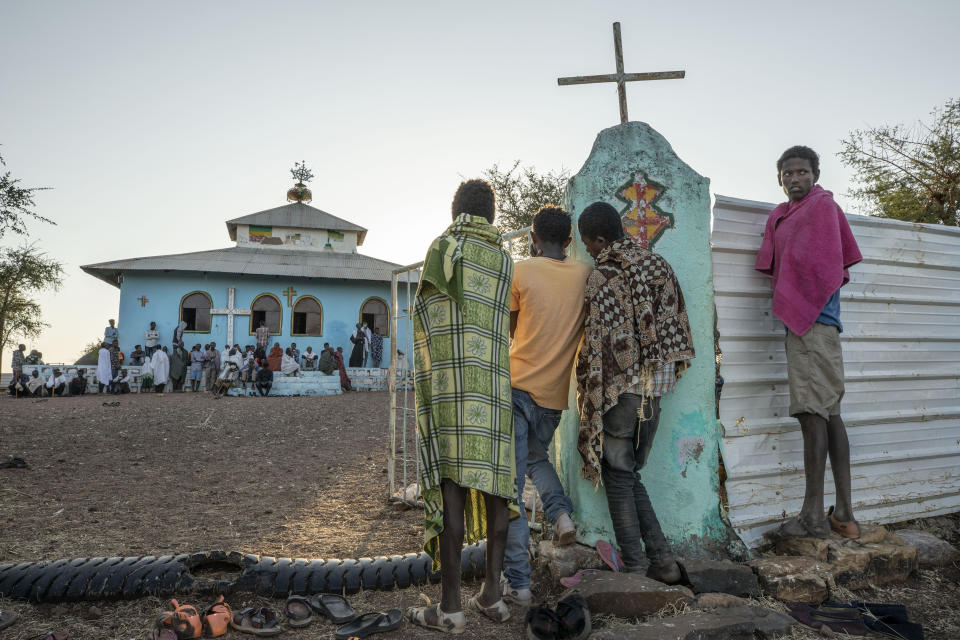 Tigrayan men who fled the conflict in Ethiopia's Tigray region, listen to a priest deliver a sermon during Sunday Mass, at a church near Umm Rakouba refugee camp in Qadarif, eastern Sudan, Nov. 29, 2020. (AP Photo/Nariman El-Mofty)