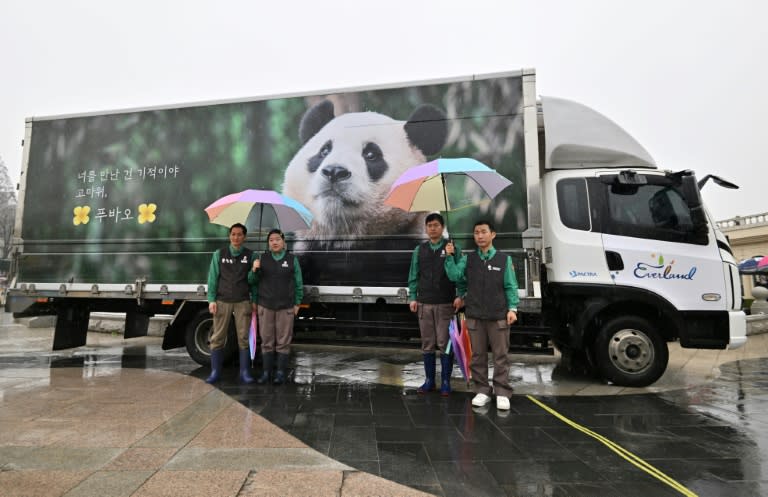 Zookeepers pose for photos in front of a vibration-free special vehicle carrying giant panda Fu Bao (Jung Yeon-je)