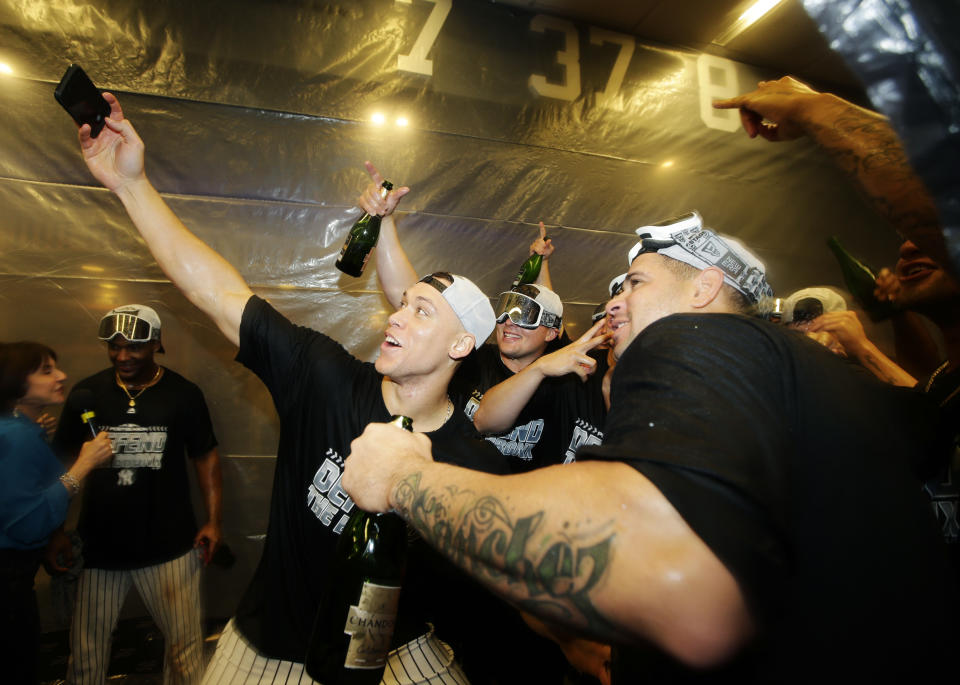 New York Yankees' Aaron Judge, left, celebrates with teammates after they clinched wildcard playoff birth with a 3-2 win over the Baltimore Orioles in a baseball game Saturday, Sept. 22, 2018, in New York. (AP Photo/Frank Franklin II)