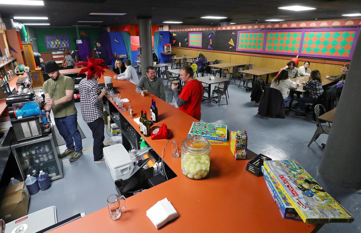 Simpsons fans take in the environment of Moe's pop-up bar inside Missing Falls Brewery as Jeff Whalen, who is dressed up as Sideshow Bob, prepares drinks Friday.