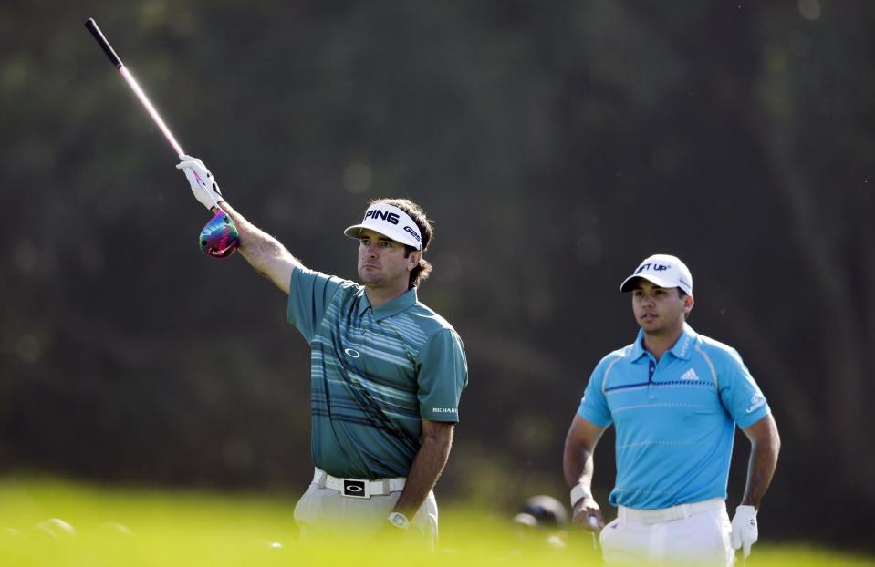 Bubba Watson, left, motions as his tee shot flies to the right of the fairway, as Jason Day, of Australia, looks on. on the 15th hole of the north course during the first round of the Farmers Insurance Open golf tournament Thursday, Jan. 23, 2014, in San Diego. (AP Photo/Gregory Bull)