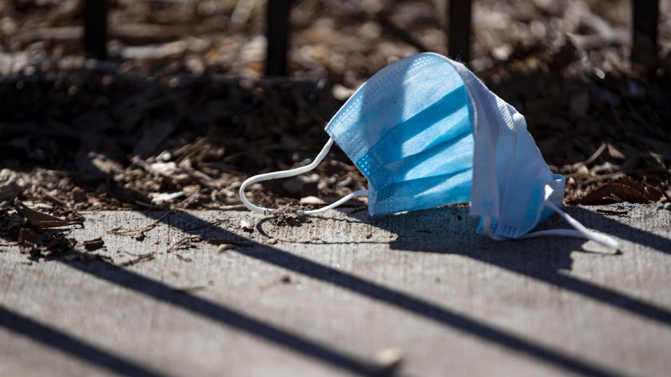 A discarded blue surgical mask lies on the sidewalk in Chicago's Lakeview neighborhood. 