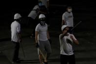 Men in white T-shirts react in Yuen Long after attacking anti-extradition bill demonstrators at a train station in Hong Kong