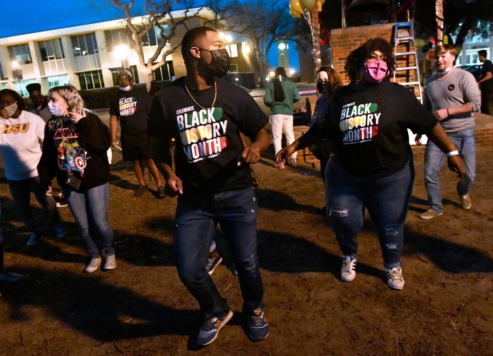Izaiha Bush (center) and Jailyn Woods-McGarthy (right) lead a group of Hardin-Simmons University students in a line dance during a campus event kicking off Black History Month in February 2021.