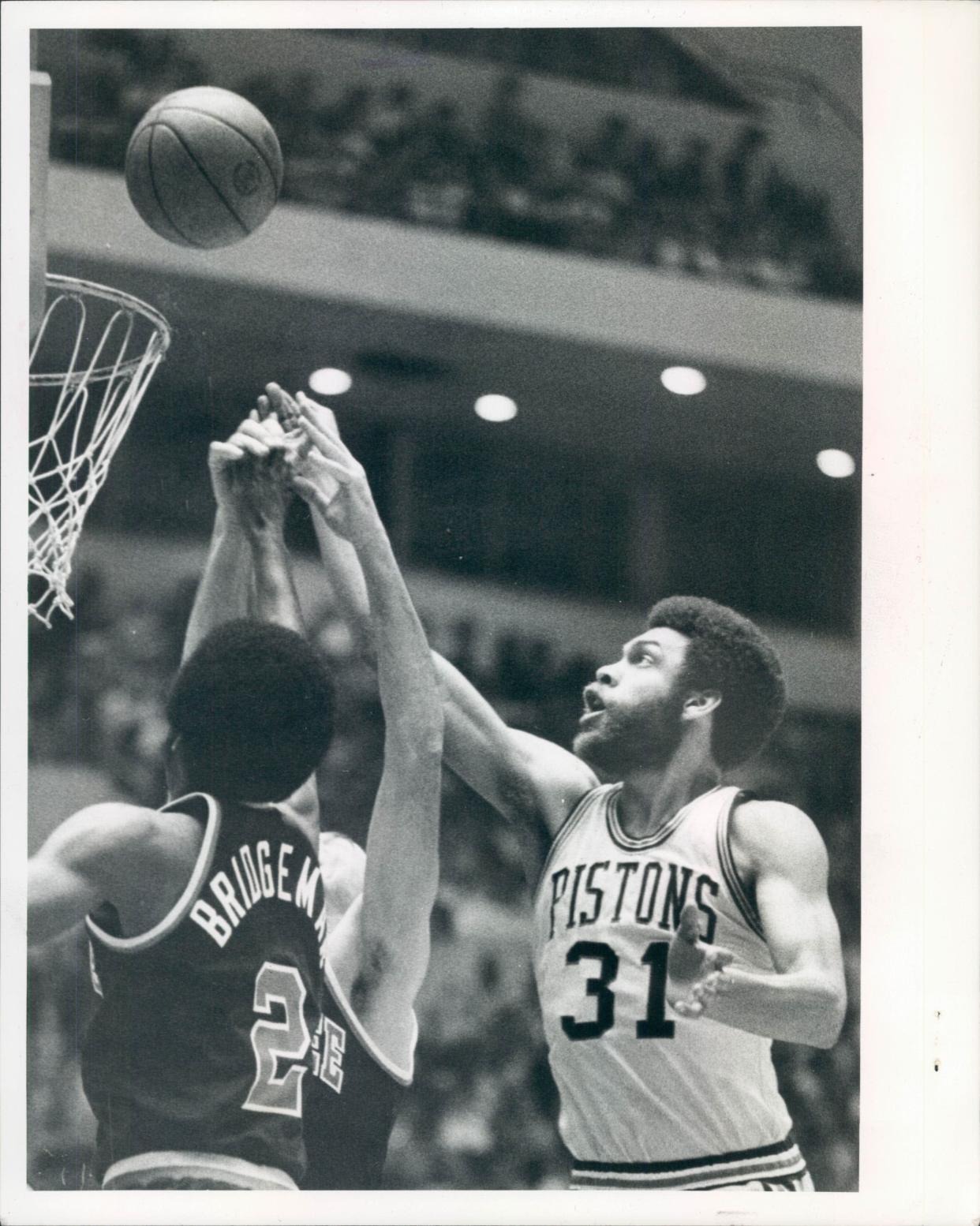 Detroit Pistons power forward George Trapp pops in a basket over Junior Bridgeman.