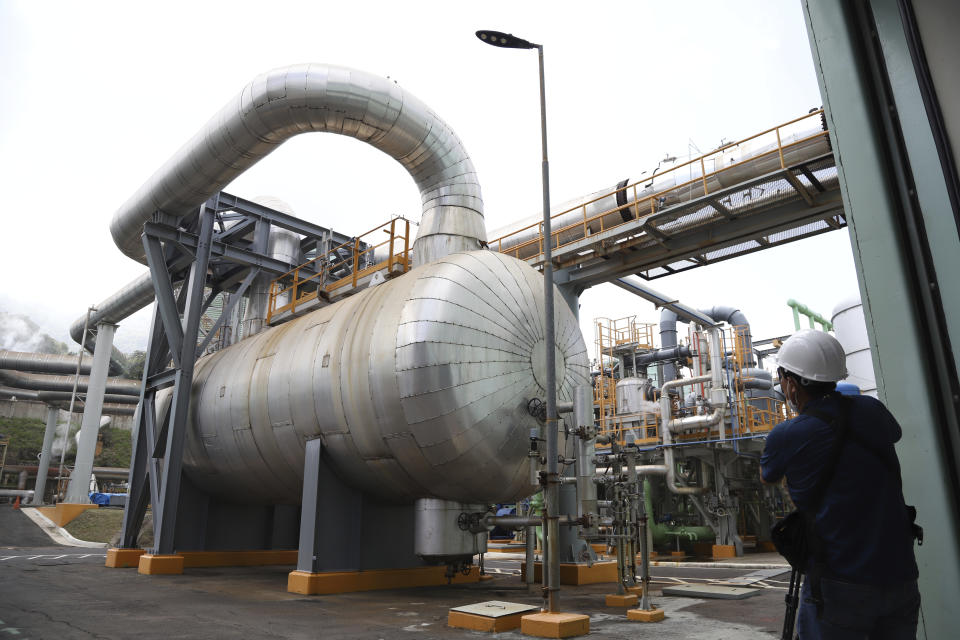 A journalist takes a photo of the cooling systems at La Geo Geothermal Power Plant in Berlin municipality, Usulutan department, El Salvador, Friday, Oct. 15, 2021. The government announced that it has installed 300 processors at this plant to "mine" cryptocurrency, and is using geothermal resources from the country’s volcanos to run the computers that perform the calculations to verify transactions in bitcoin, recently made legal tender. (AP Photo/Salvador Melendez)