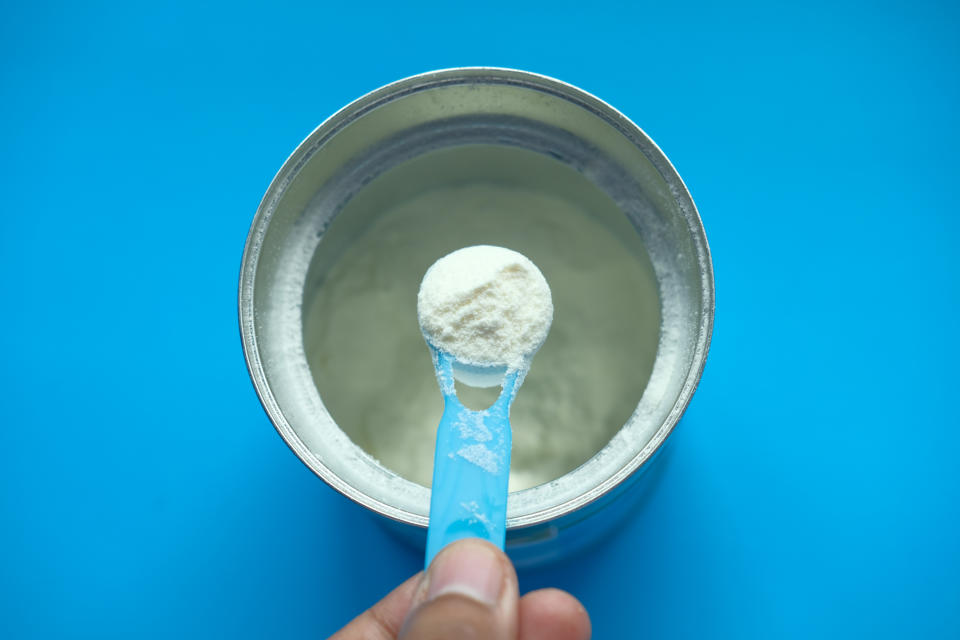 A picture of a baby formula tin with scoop. 